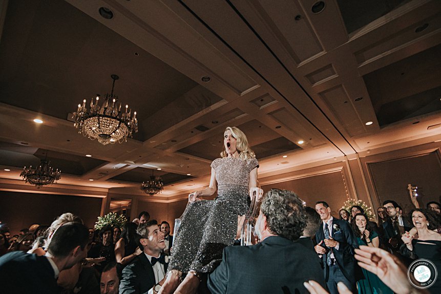 jewish wedding at the logan hotel , mom being lifted in a chair for the hora dance