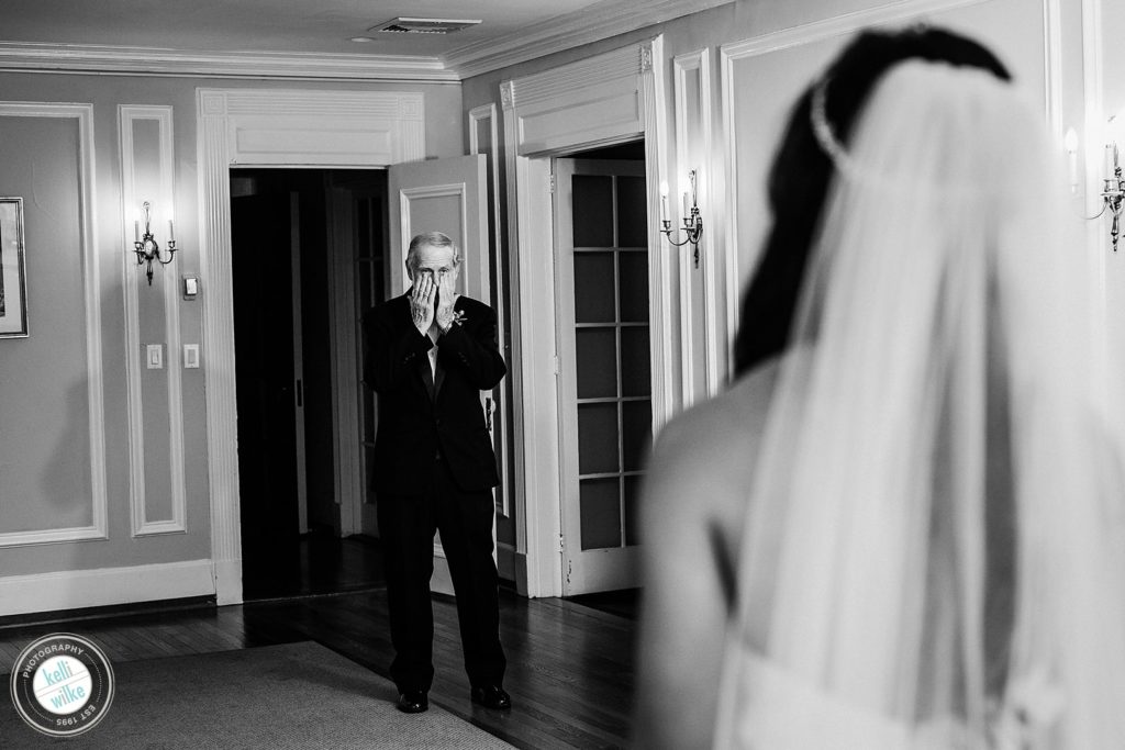 A father wipes his tears when he sees his daughter in her wedding dress for the first time at Greenville Country Club in Greenville DE 