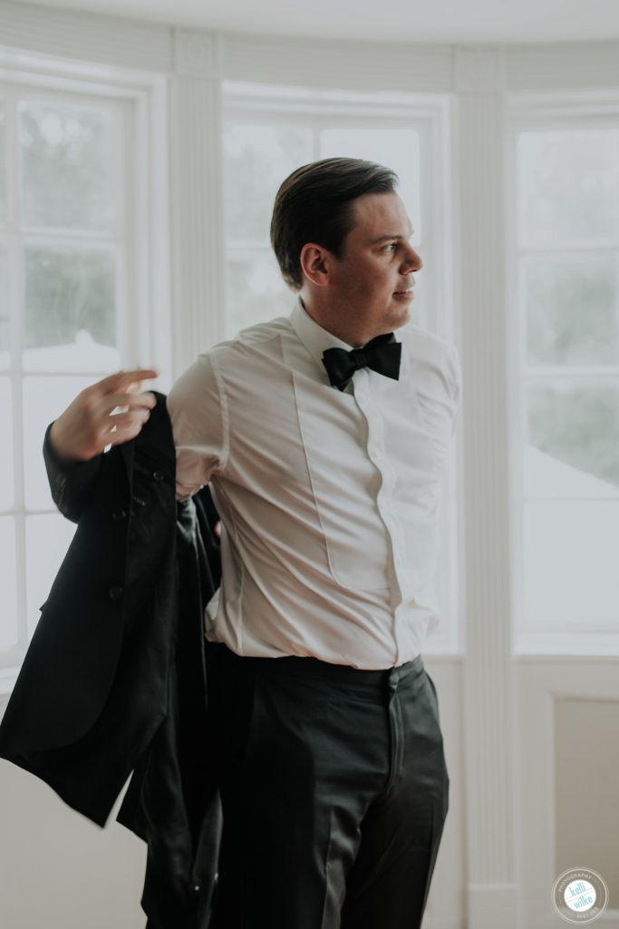 Groom puts his jacket on before his wedding ceremony at Greenville Country Club in Greenville DE