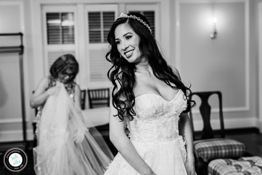 Bride's mom helps her daughter with her wedding veil and dress (Lazaro Wedding Dress) at Greenville Country Club in Greenville Delaware