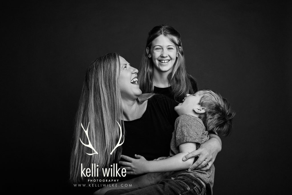 mother with daughter and son in a black and white portrait