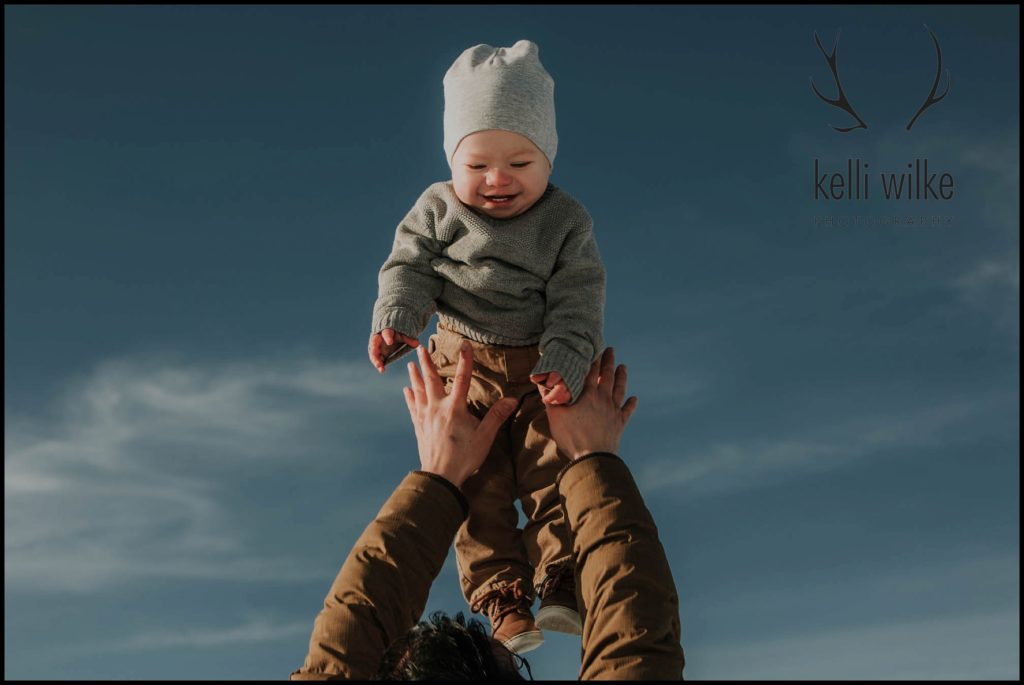 child laughs while being thrown in the air 